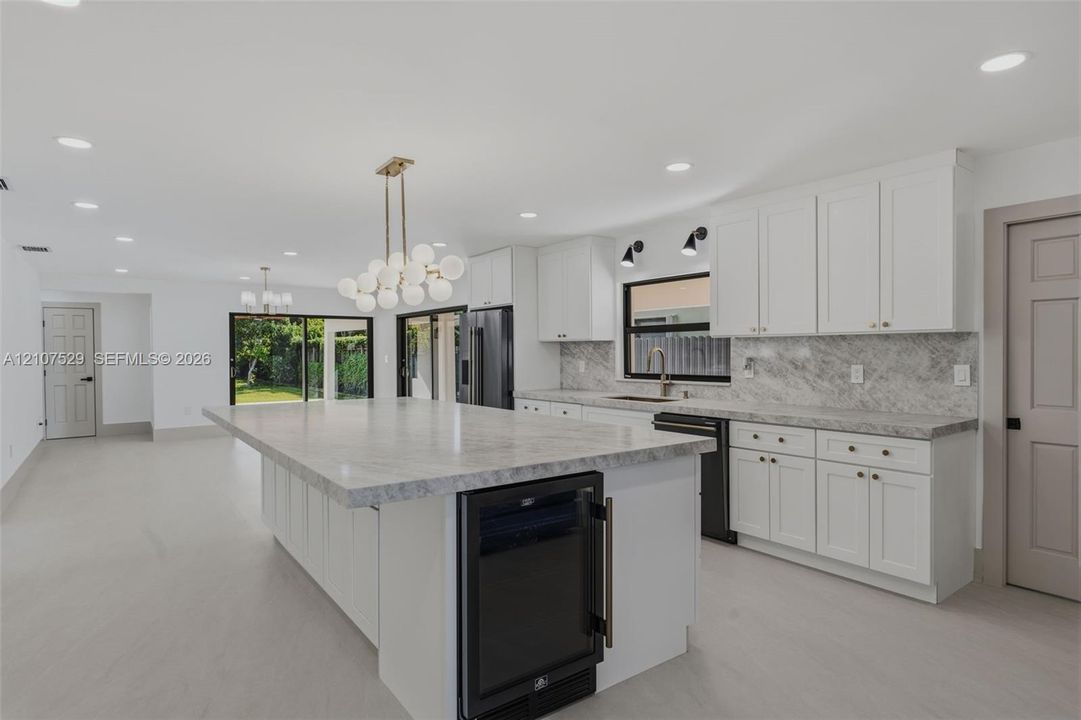 Covered patio featuring a natural wood-plank ceiling, recessed lighting, ceiling fan, expansive tile flooring, and large-format sliding glass doors