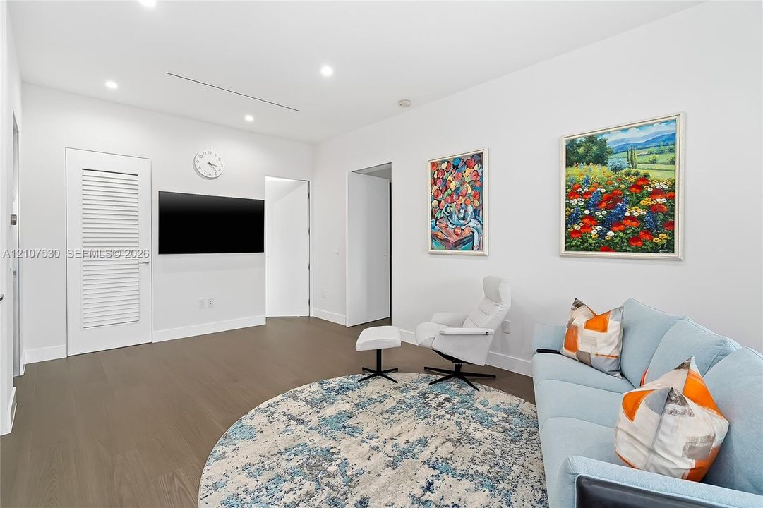 Neutral-toned interior featuring wood-finish flooring, recessed lighting, and a louvered-panel door