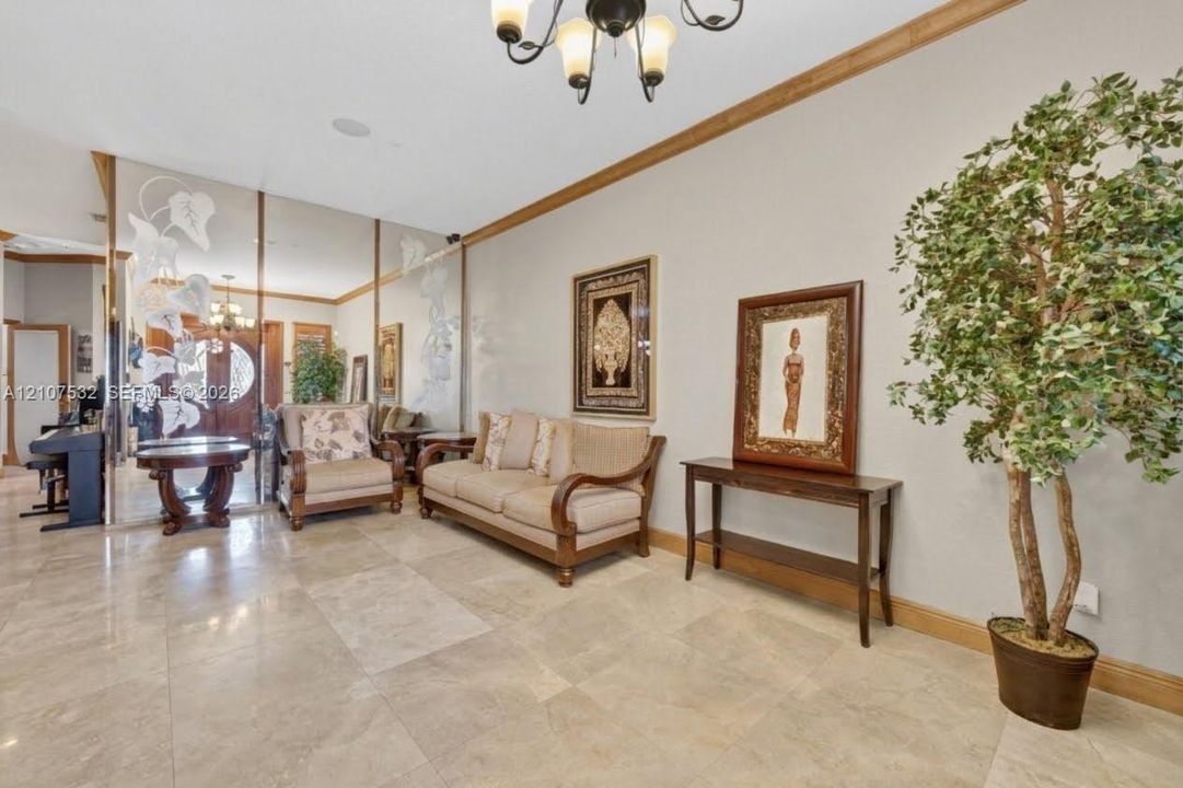 Large-format stone tile flooring, wall-to-wall mirrored panels featuring decorative frosted etching, and crown molding