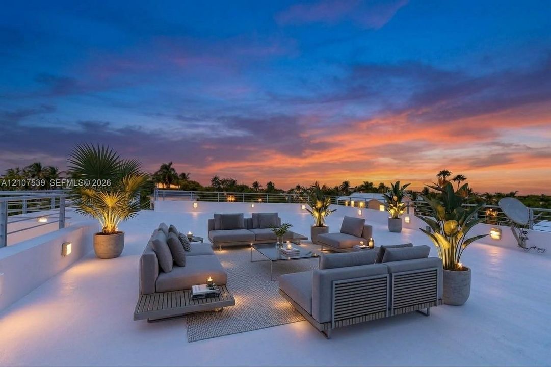 Expansive rooftop terrace featuring a smooth-finish deck, metal perimeter railing, and integrated wall-mounted lighting