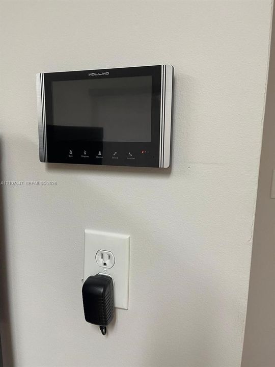 Wall-mounted digital intercom system featuring a sleek black-and-silver interface