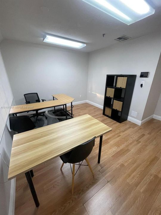 Room featuring wood-finish flooring, neutral wall paint, and dual ceiling-mounted rectangular light fixtures