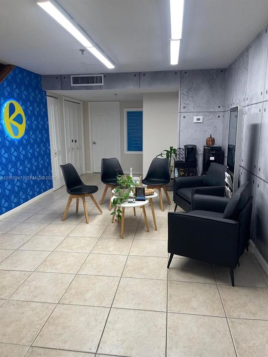 Large-format tile flooring, industrial-style concrete-finish wall panels, and linear overhead lighting