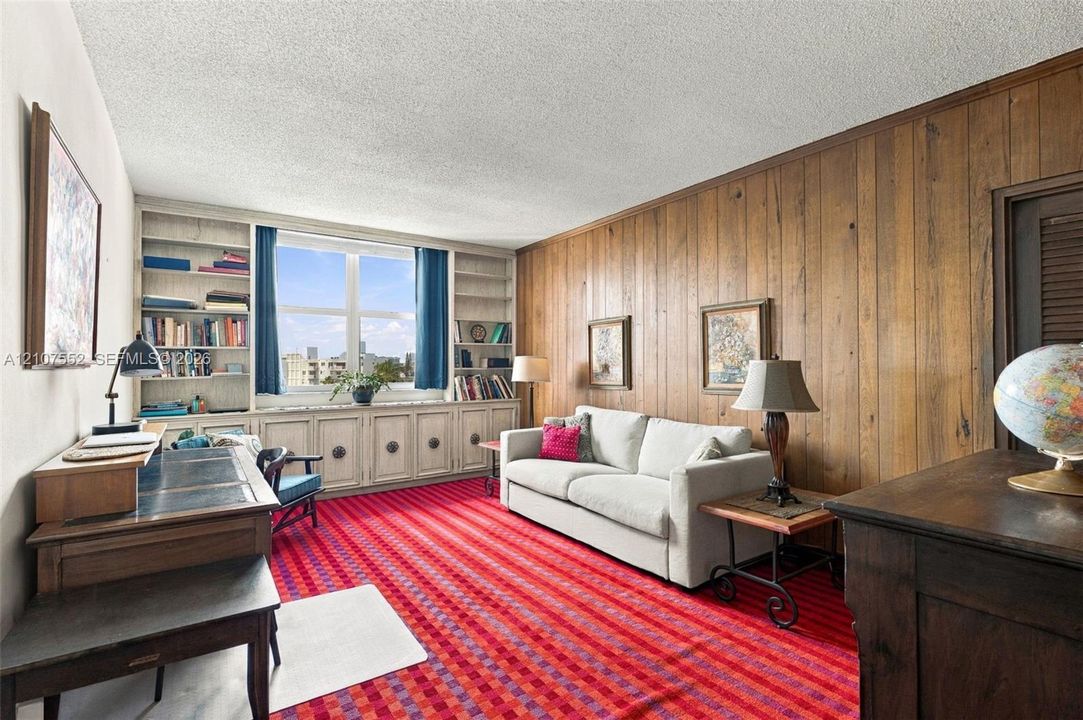 Wood paneling, expansive built-in cabinetry with integrated shelving, and large window