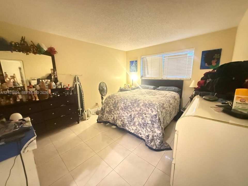 Interior room featuring light-toned tile flooring and horizontal window blinds