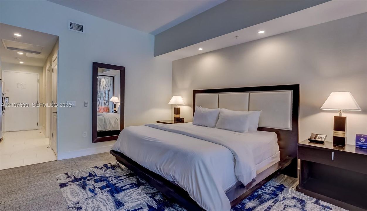 High ceilings with recessed lighting, neutral wall finishes, and wall-to-wall carpeting
