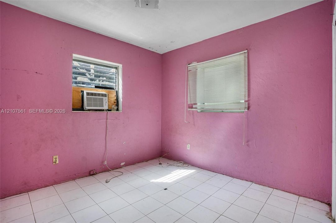 Room featuring white tile flooring and two windows with horizontal blinds