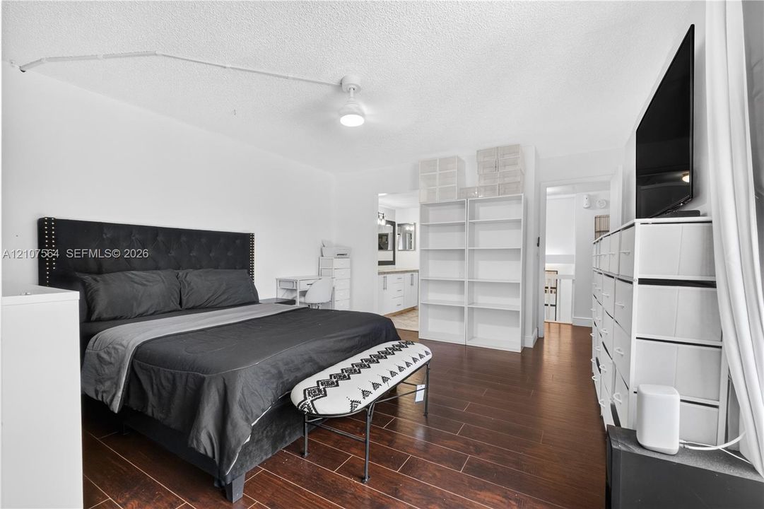 Wood-finish flooring and white built-in shelving