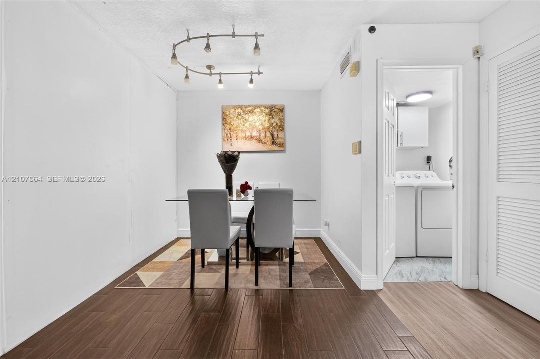 Wood-finish flooring, curved track lighting, and louvered closet doors