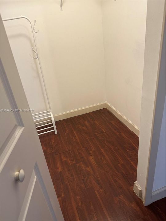 Storage space featuring wood-finish flooring and a built-in wire shelving rack