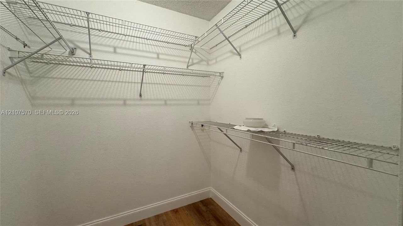 Storage area featuring wood-finish flooring and multi-level white wire shelving