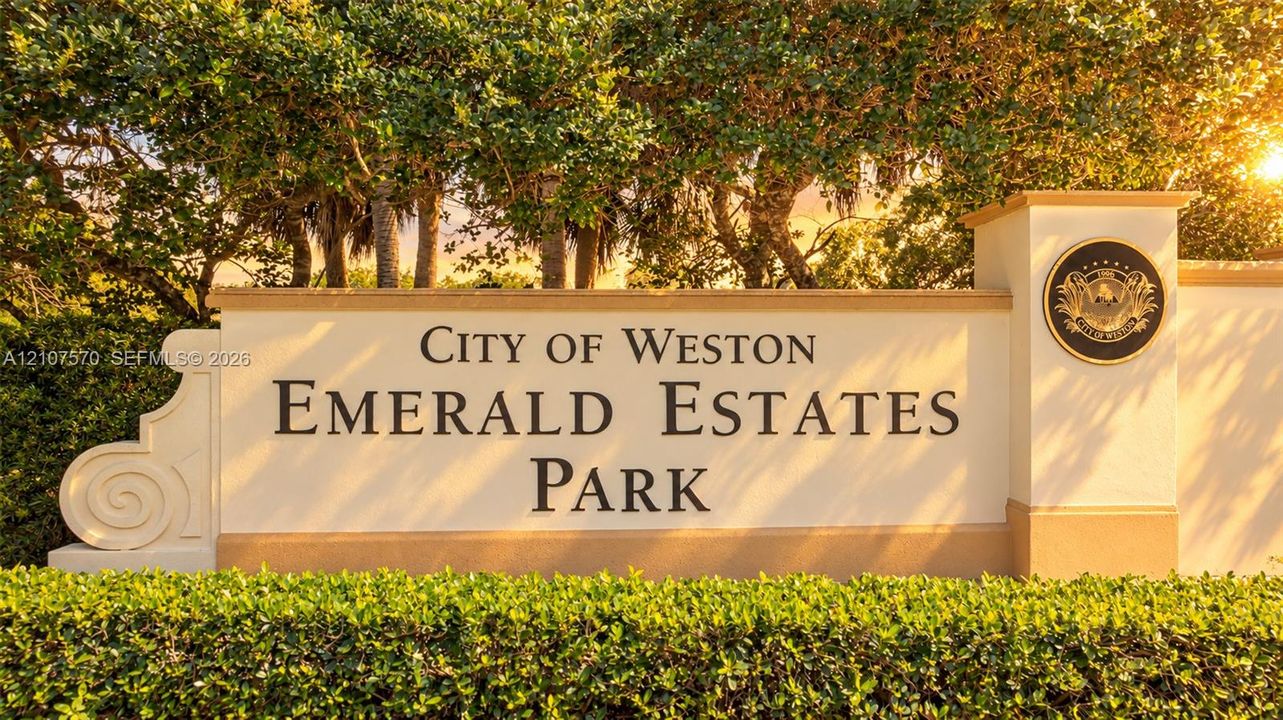 Stucco monument sign featuring raised lettering, integrated decorative medallion, and professional landscaping