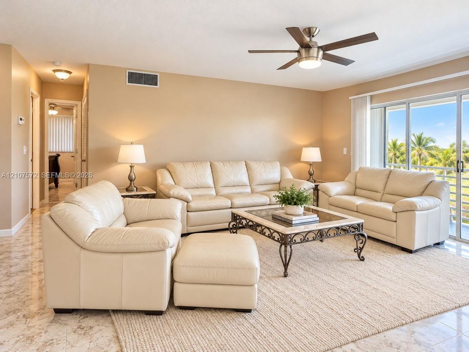 Living area featuring tile flooring, a multi-blade ceiling fan with integrated light fixture,