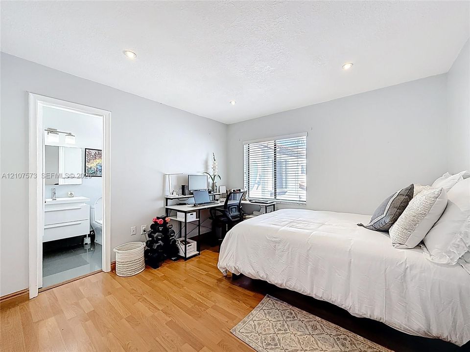 Room featuring wood-finish flooring, recessed lighting, and a window with horizontal blinds
