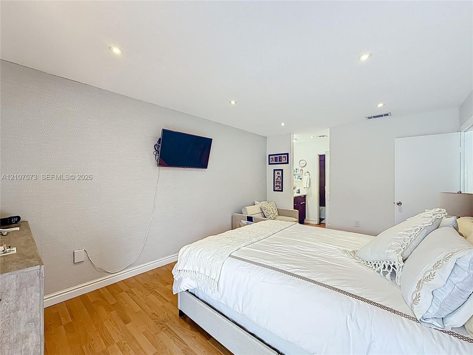 Neutral-toned room with wood-finish flooring and recessed ceiling lighting