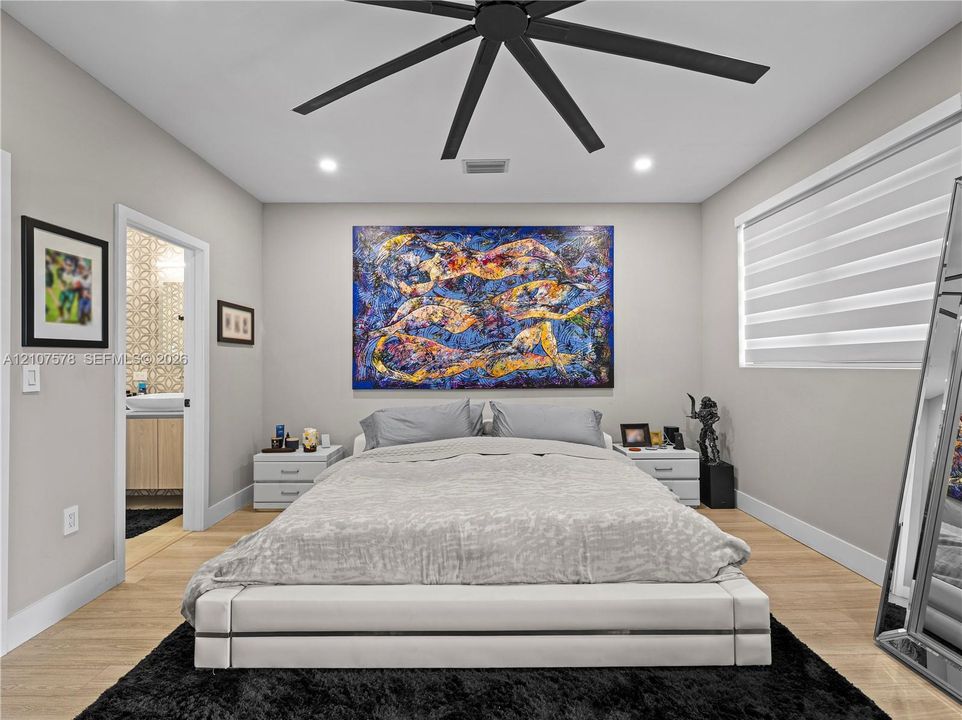 Neutral-toned interior featuring wood-finish flooring, a contemporary multi-blade ceiling fan, recessed lighting, and adjustable horizontal window blinds