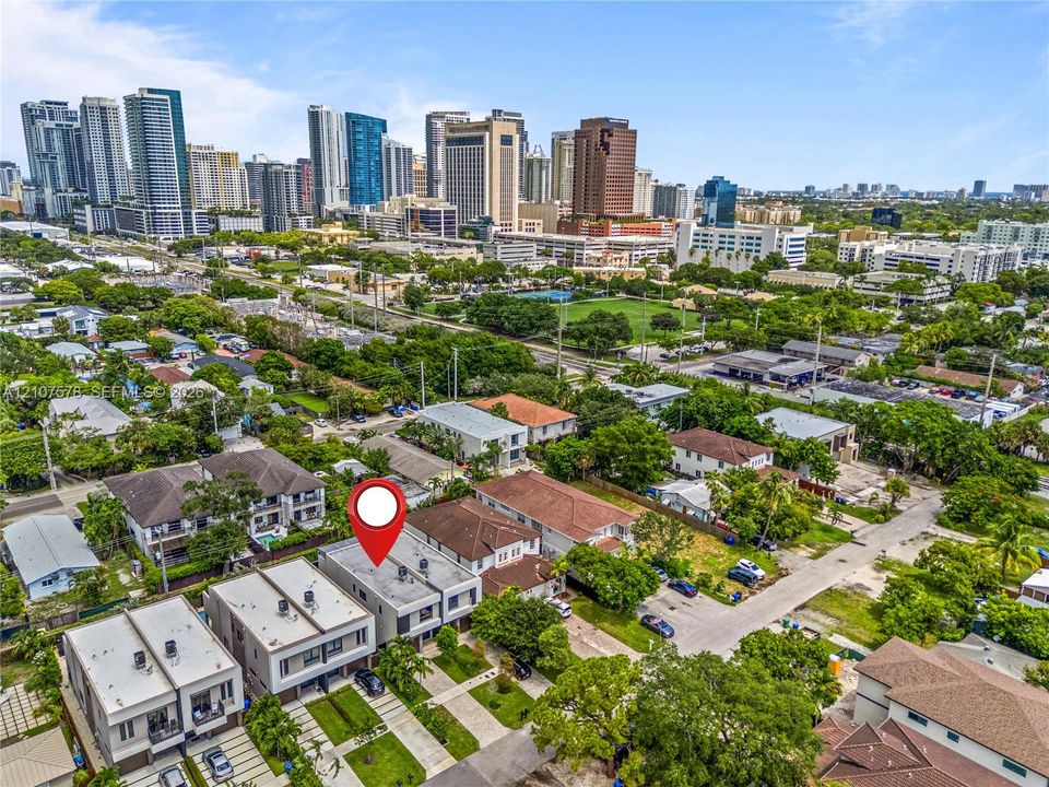 Aerial view of modern multi-story residential structures featuring flat rooflines, integrated balconies, and paved driveways