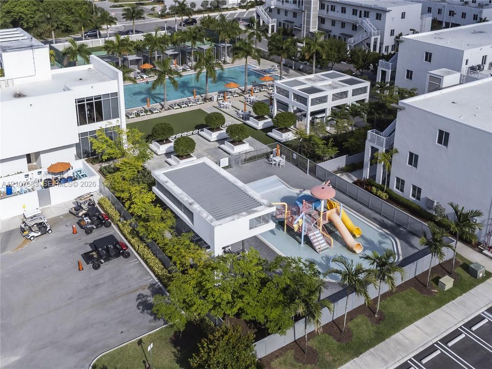 Community amenities featuring a swimming pool, covered pavilion, splash park with slides, and manicured landscaping