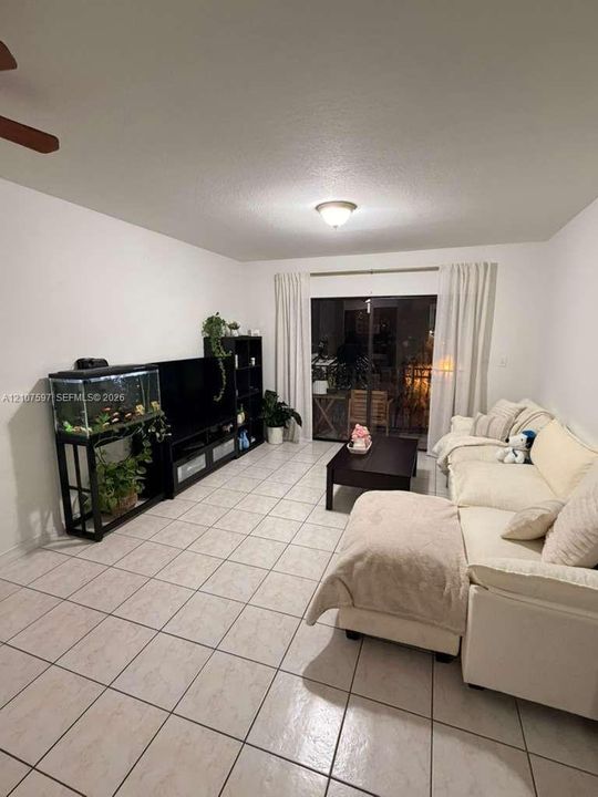Ceramic tile flooring, neutral wall finishes, ceiling-mounted light fixture, ceiling fan, and sliding glass door