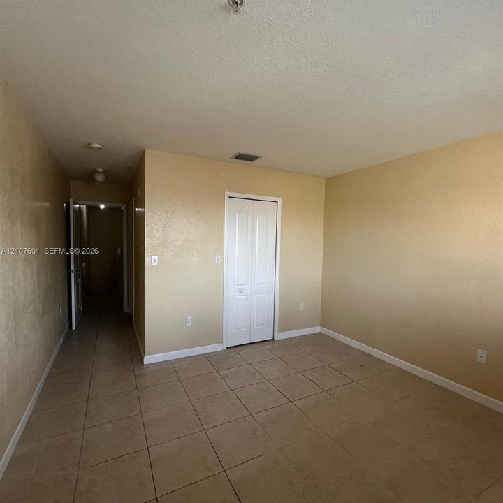 Room featuring ceramic tile flooring, neutral wall finish, and a white bi-fold closet door