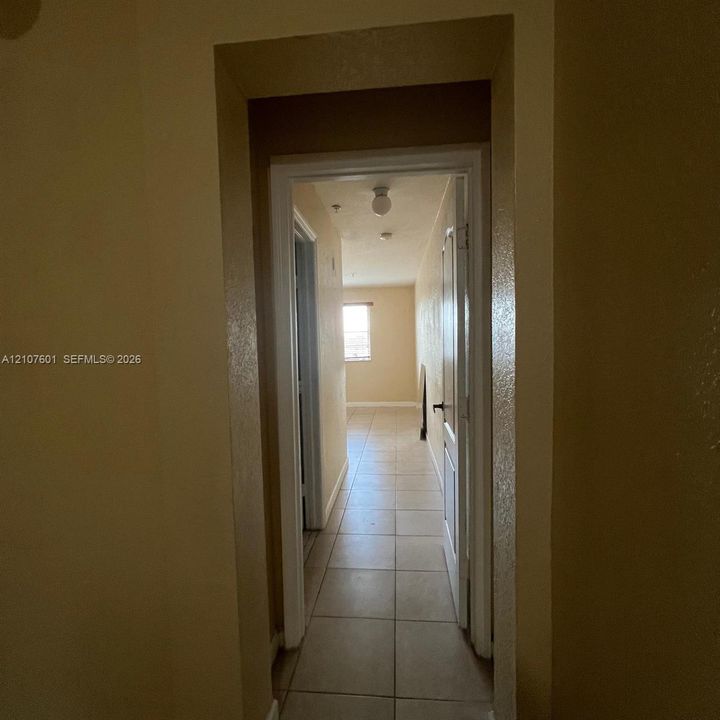 Ceramic tile flooring, white-trimmed door frames, and flush-mount ceiling light fixture