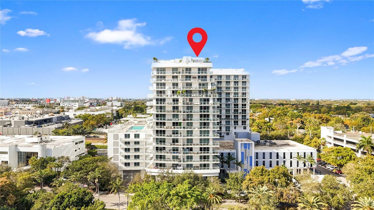 High-rise residential building featuring expansive private balconies, floor-to-ceiling glass windows, and rooftop amenities