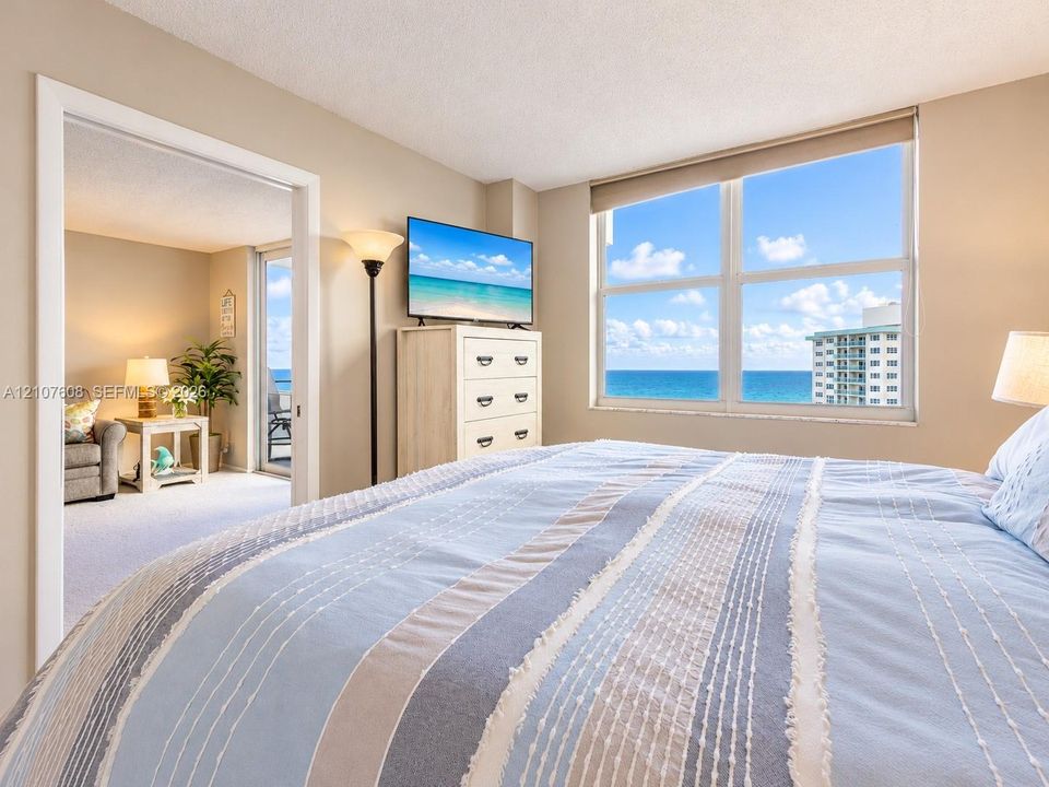Large windows with ocean horizon and coastal scenery, wall-to-wall carpeting, and sliding glass door