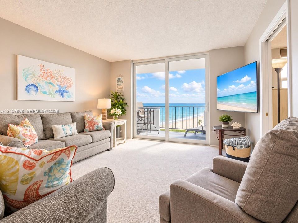 Sliding glass doors providing access to a private balcony with ocean frontage