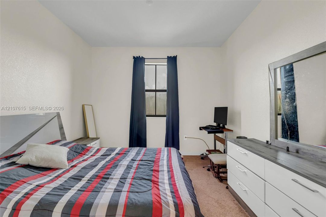 Interior room featuring neutral wall paint, carpeting, and a central window with black mullions