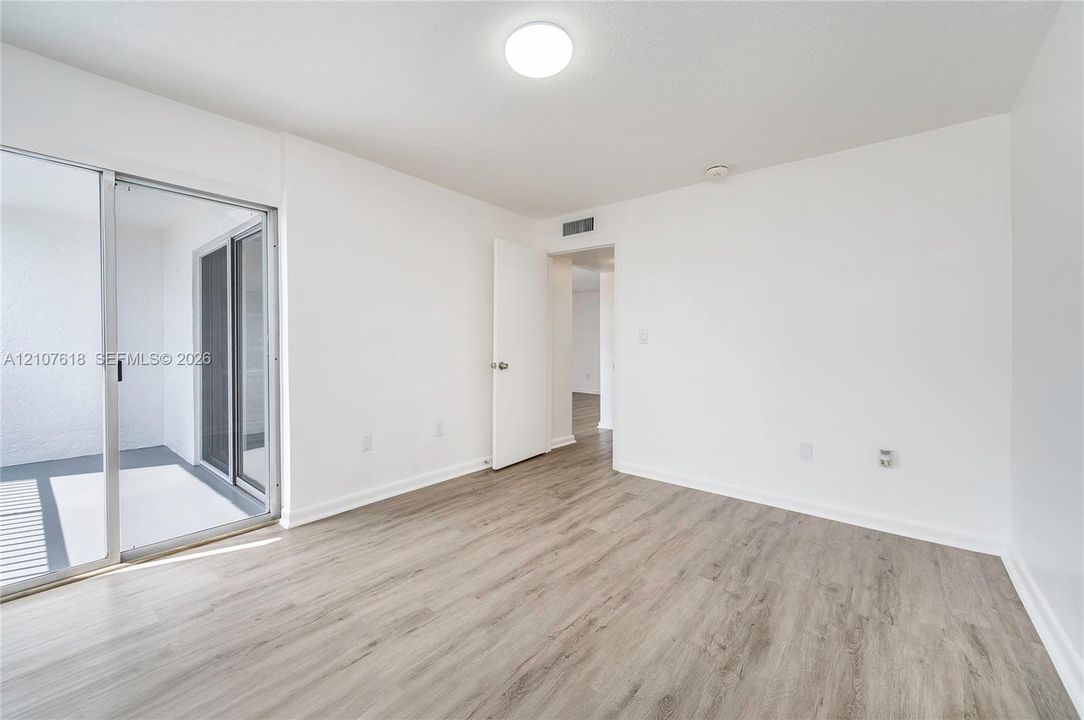 Interior space featuring wood-finish flooring, sliding glass door, and flush-mount lighting