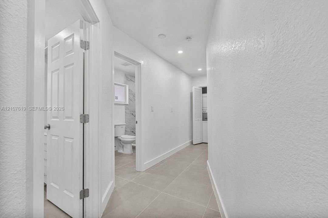 Neutral-toned large-format tile flooring, recessed ceiling lighting, and crisp white interior wall finishes