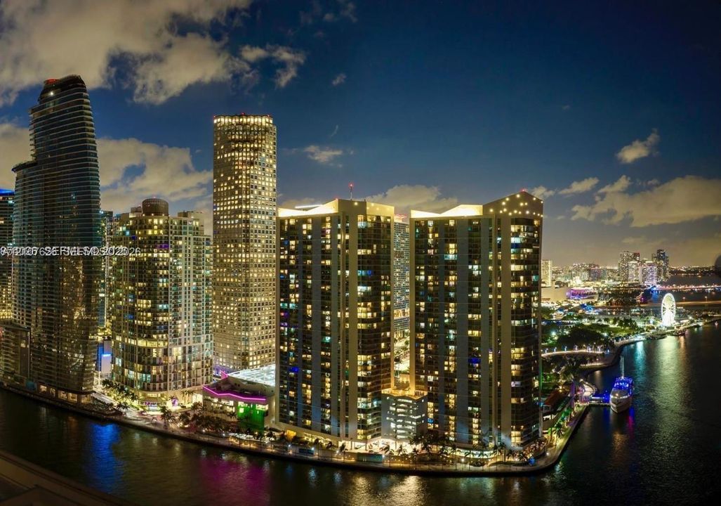 Panoramic urban skyline featuring high-rise architecture, proximity to the waterfront, and expansive cityscape illumination