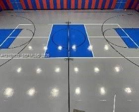 Indoor sports court featuring a high-gloss finish, painted court boundaries, and wall-mounted padded paneling