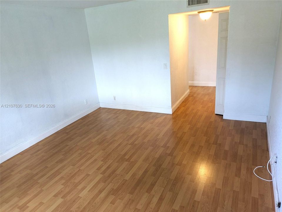 Interior space featuring wood-finish flooring, smooth white walls, and a recessed ceiling lighting fixture