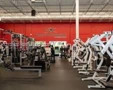Expansive fitness facility featuring high-clearance open-truss ceilings, durable rubberized flooring, and floor-to-ceiling windows