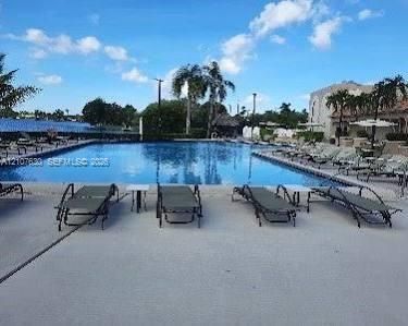Inground swimming pool featuring a concrete deck and waterfront setting