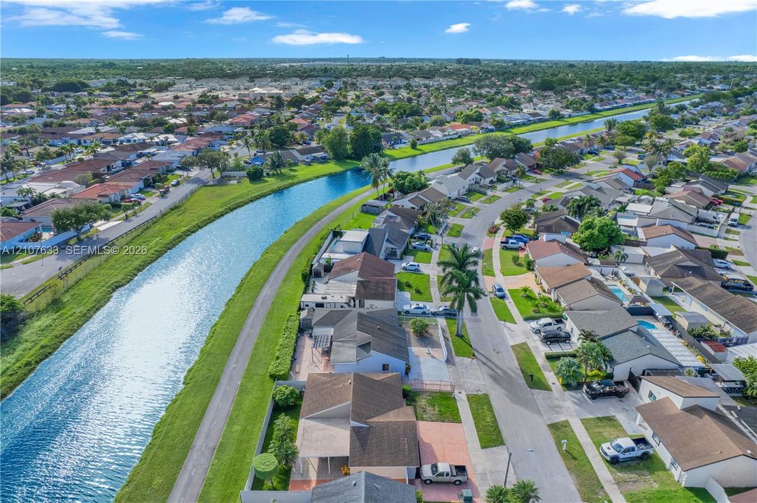 Aerial perspective featuring a waterfront location along a canal with paved path and surrounding residential development