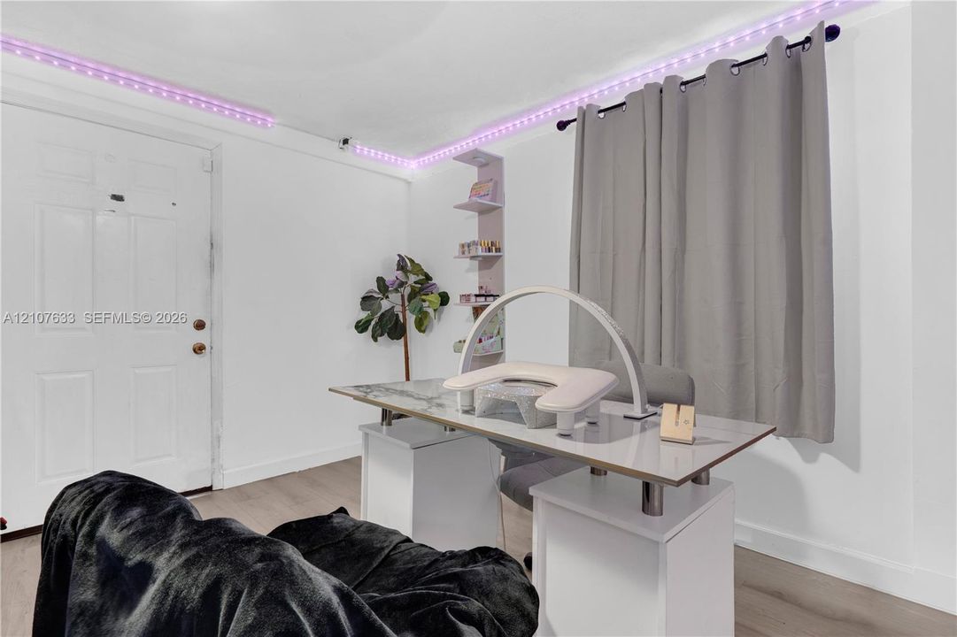 Interior space featuring wood-finish flooring, white door, and built-in recessed shelving