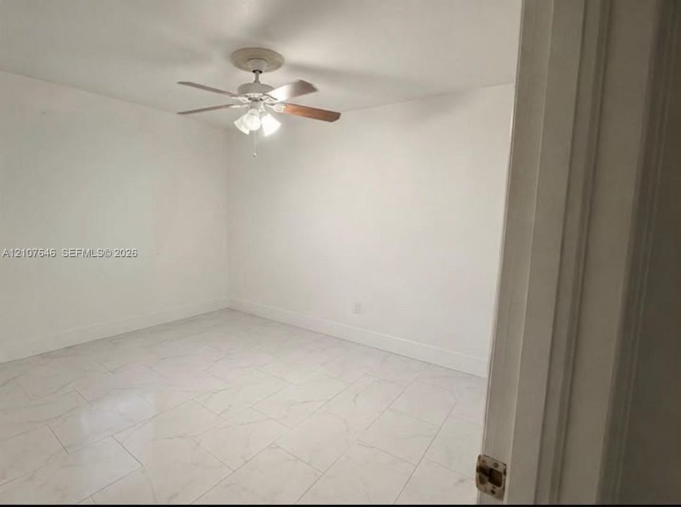 Interior room featuring white-toned tile flooring with marble-style veining and a ceiling fan with integrated multi-bulb light fixture