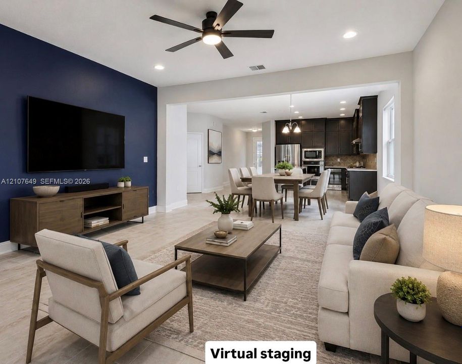 Open-concept living space featuring wood-finish flooring, a matte navy blue accent wall, recessed lighting, and a modern ceiling fan