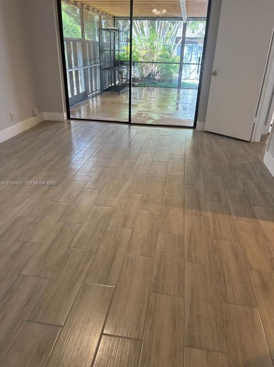 Wood-finish flooring, sliding glass door, and screened-in patio area