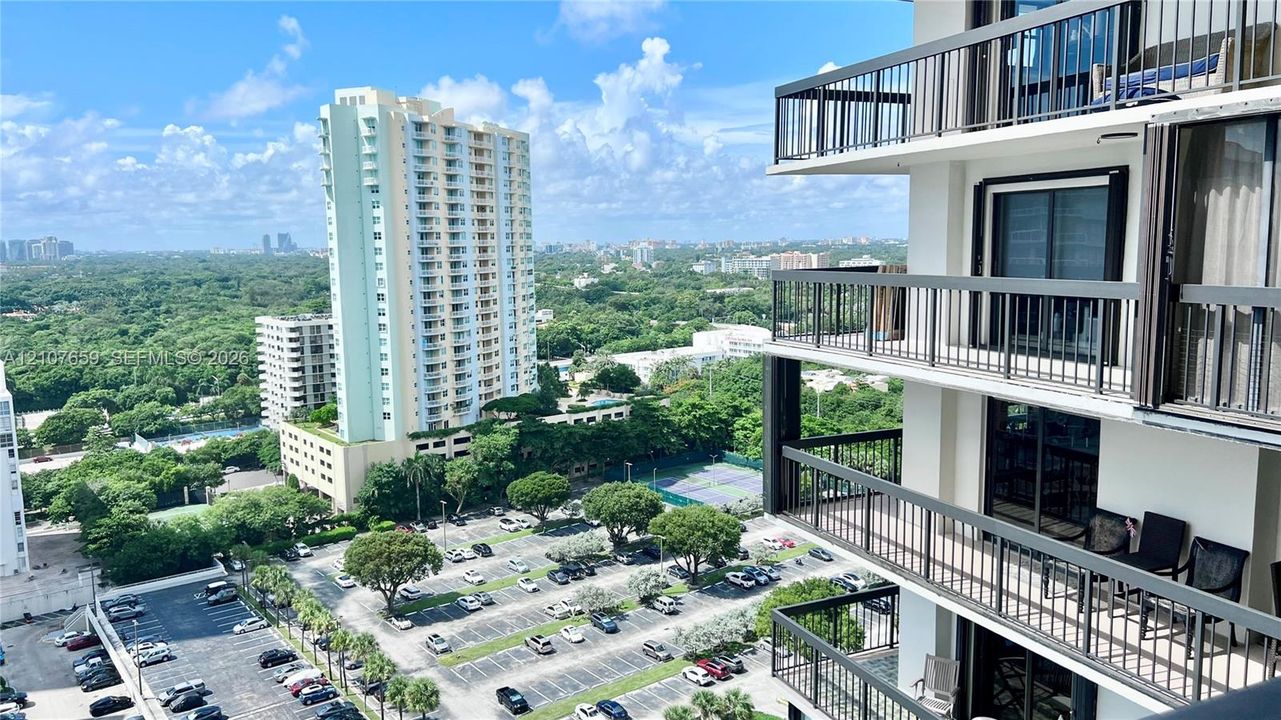 High-rise structure featuring stacked private balconies with black metal railings and sliding glass doors