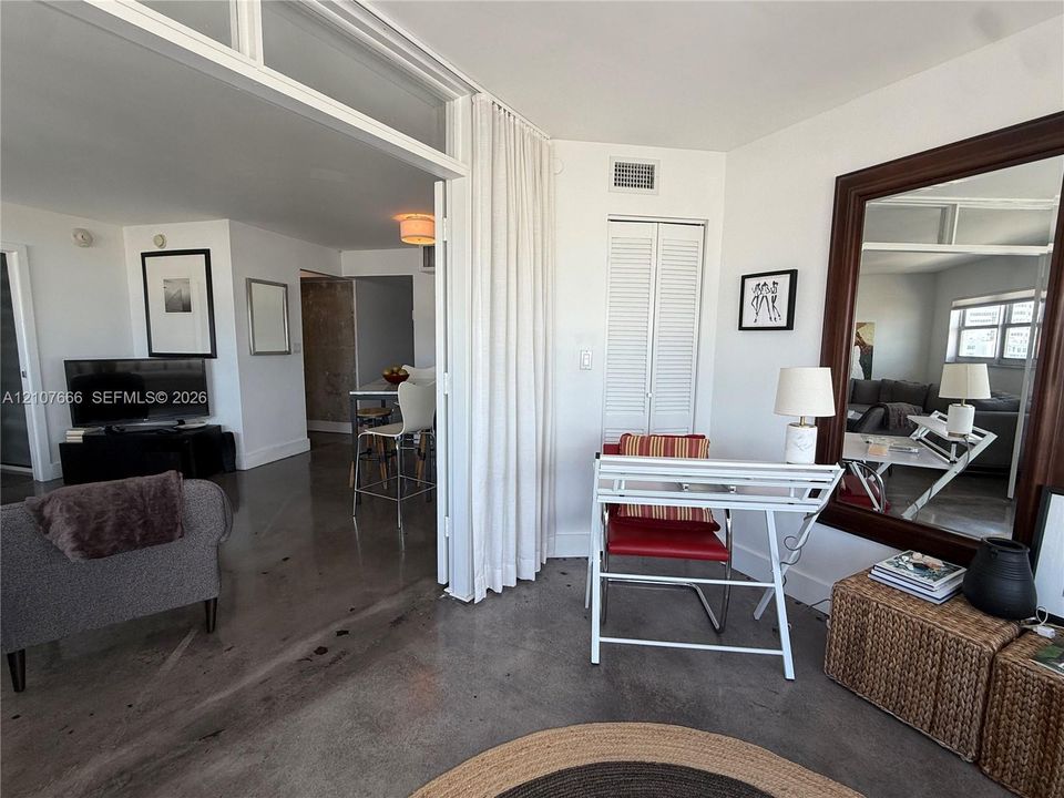 Polished concrete flooring, floor-to-ceiling glass panel partitions, and louvered closet doors
