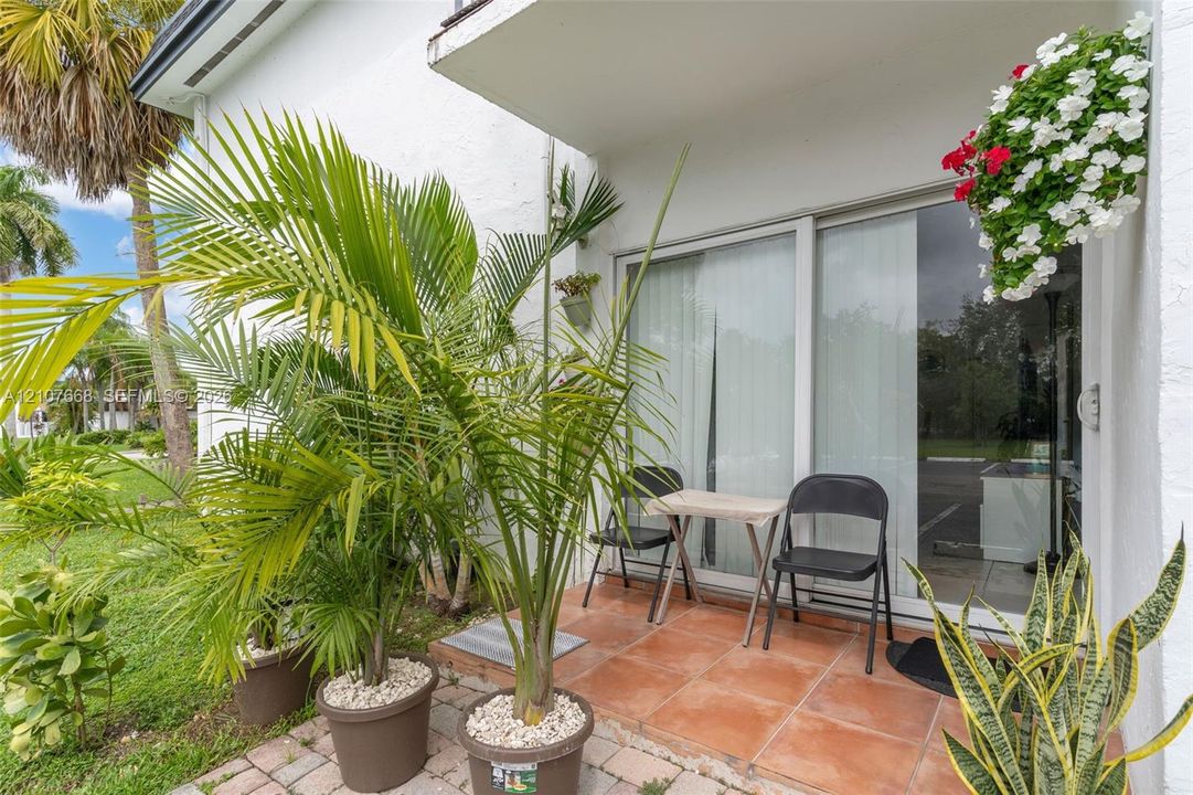 Ground-level patio featuring terracotta-toned tile flooring and sliding glass door entry