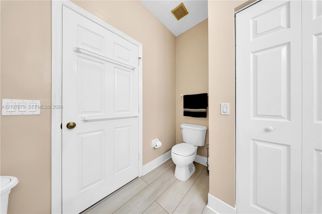 Wood-finish flooring, two-panel interior doors, and a porcelain toilet