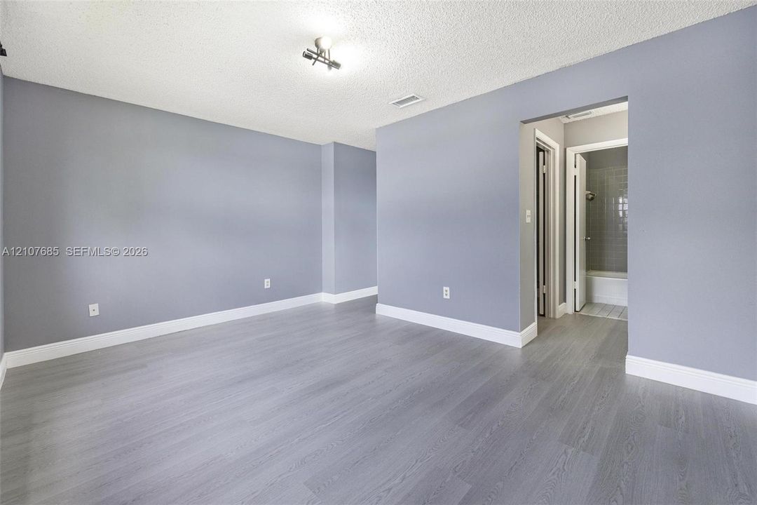 Room featuring wood-finish flooring, neutral wall tones, and recessed ceiling lighting