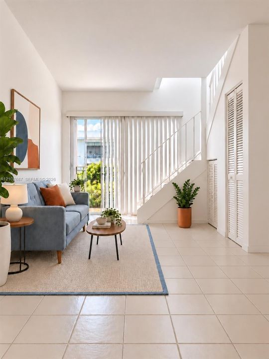 Interior space featuring neutral floor tiling, sliding glass doors, built-in closet storage with louvered doors, and a staircase with a metal railing