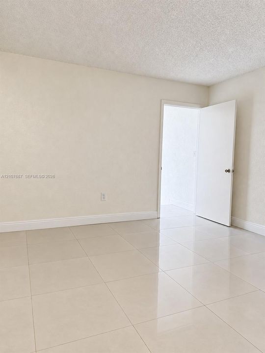 Neutral-toned interior space featuring polished large-format tile flooring and smooth-finish walls