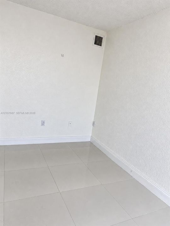 Interior space featuring neutral wall textures and large-format tile flooring