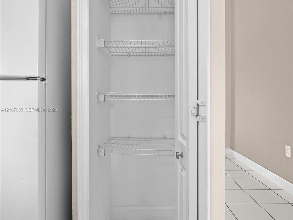 Built-in storage closet featuring three-tier wire shelving and a paneled door